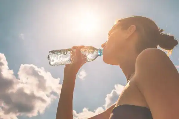 Hydration: The Secret Ingredient for a Toned Stomach and Enhanced Fitness 3 Image of woman drinking water to hydrate Chippenham after run.