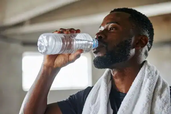 Hydration: The Secret Ingredient for a Toned Stomach and Enhanced Fitness 1 Image of man drinking water to improve hydration Chippenham after work out.